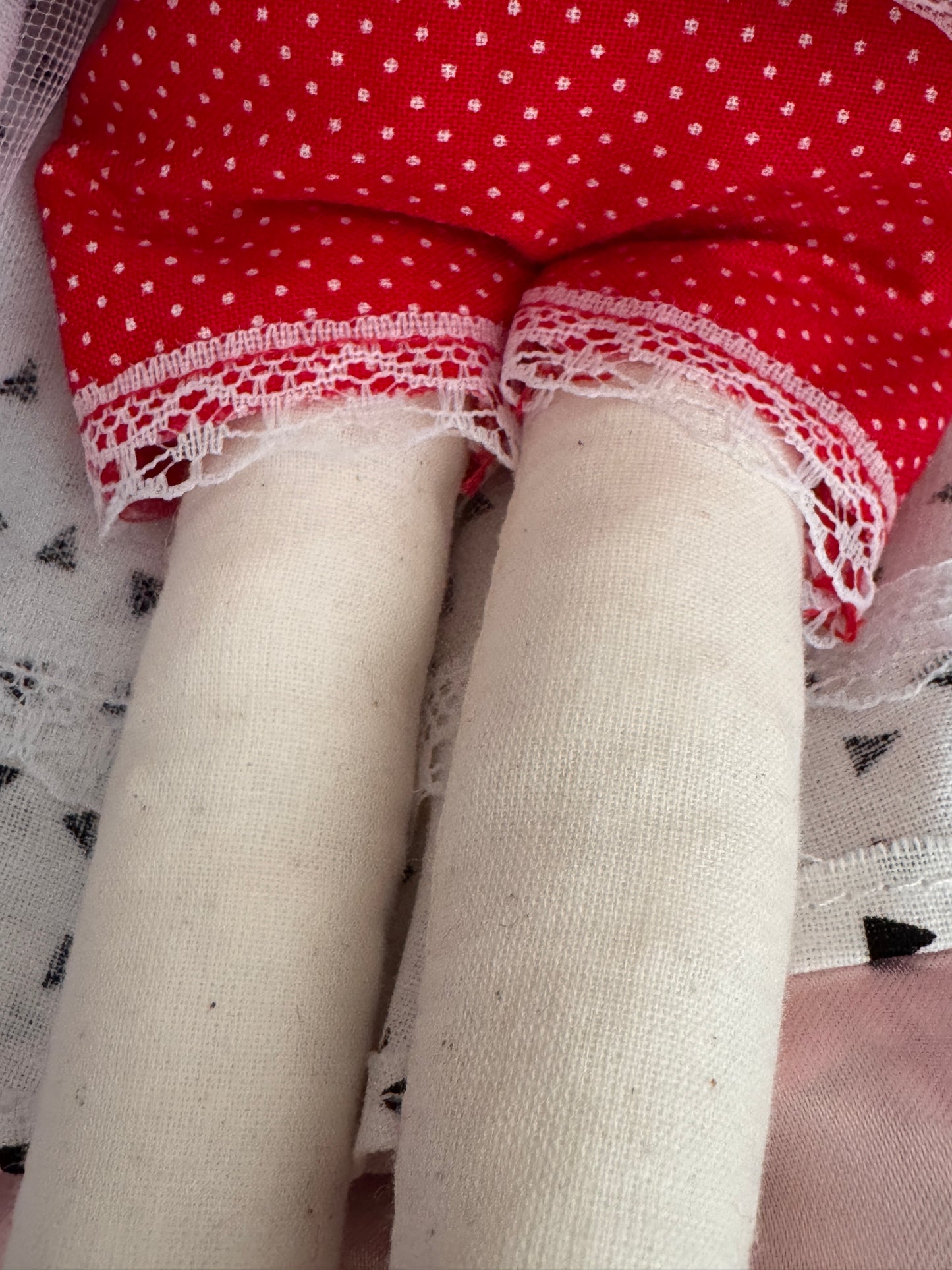 White tights with red polka dot fabric and lace trim on a patterned surface
